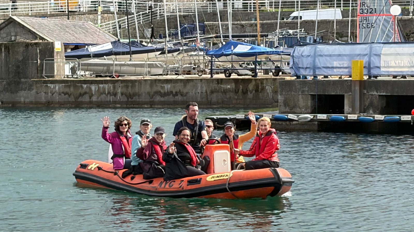People waving and smiling on the sea from a rib boat